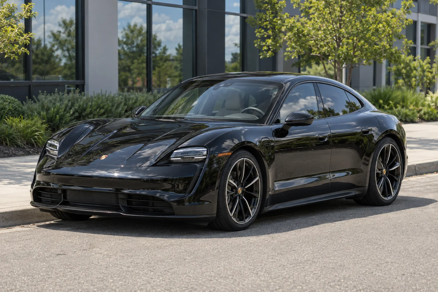 A black Porsche Taycan with ceramic window tint in the sun