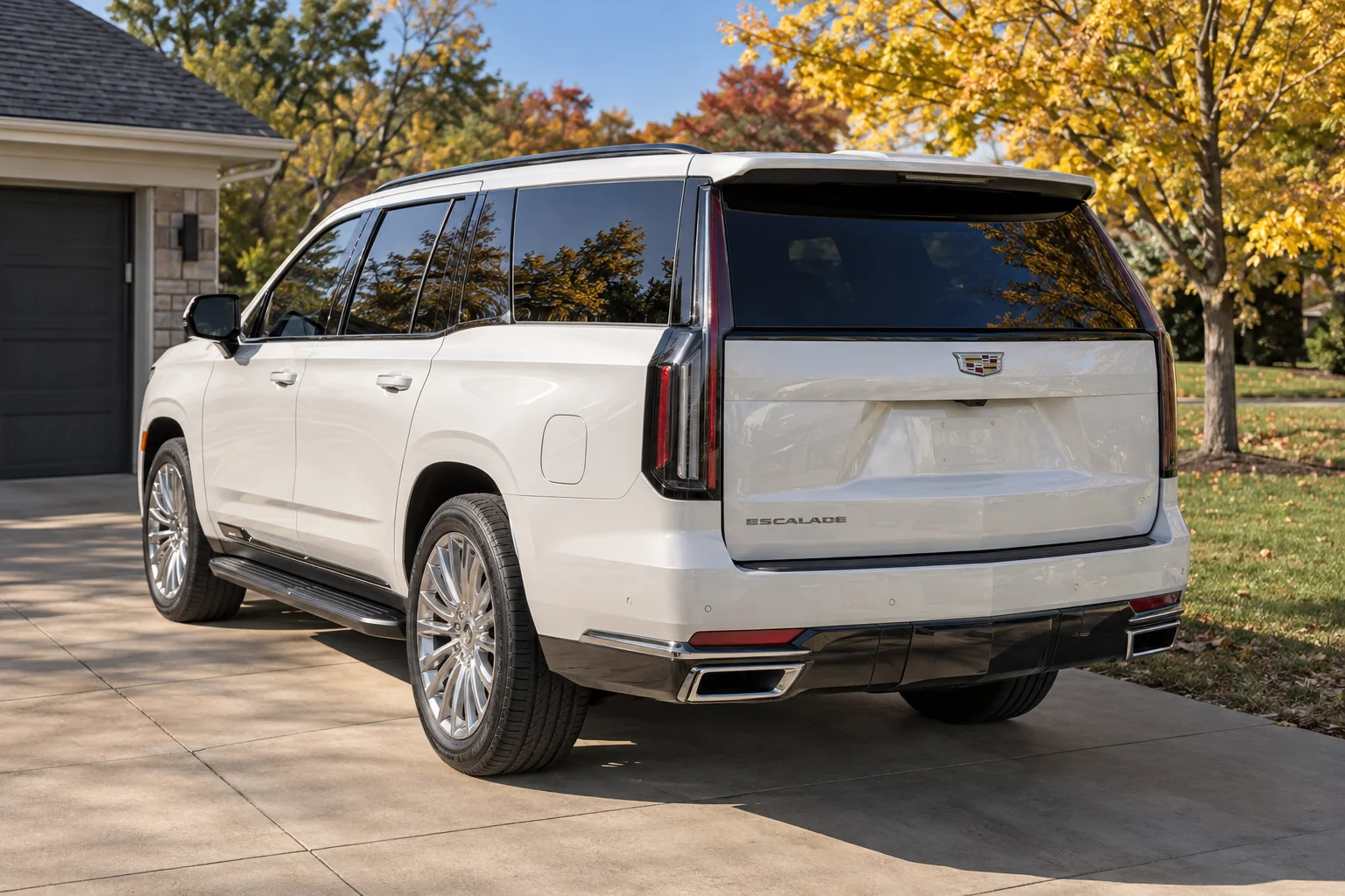 A white Cadillac Escalade with tinted windows on a driveway