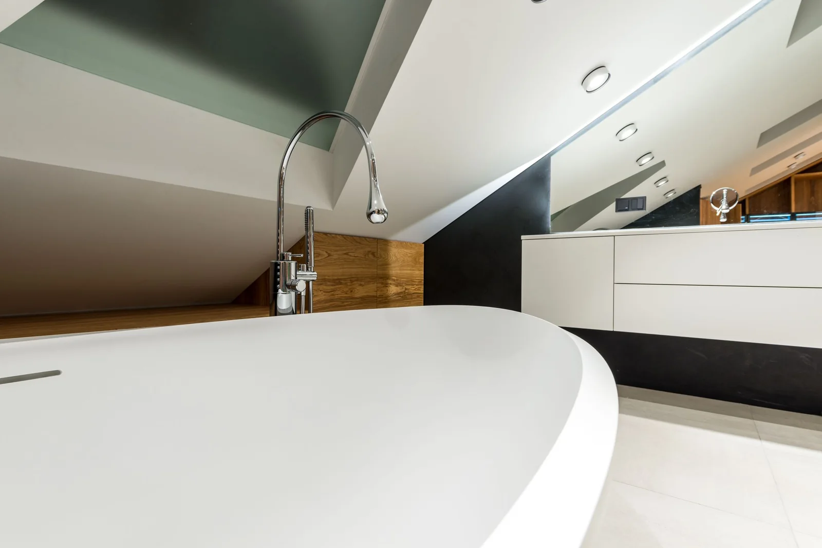 A bathroom with a freestanding tub under a sloped ceiling