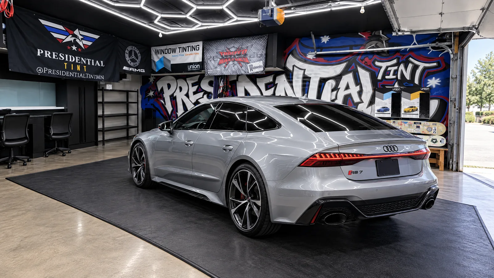 A silver Audi RS 7 with tinted windows in the Presidential Tint MN shop